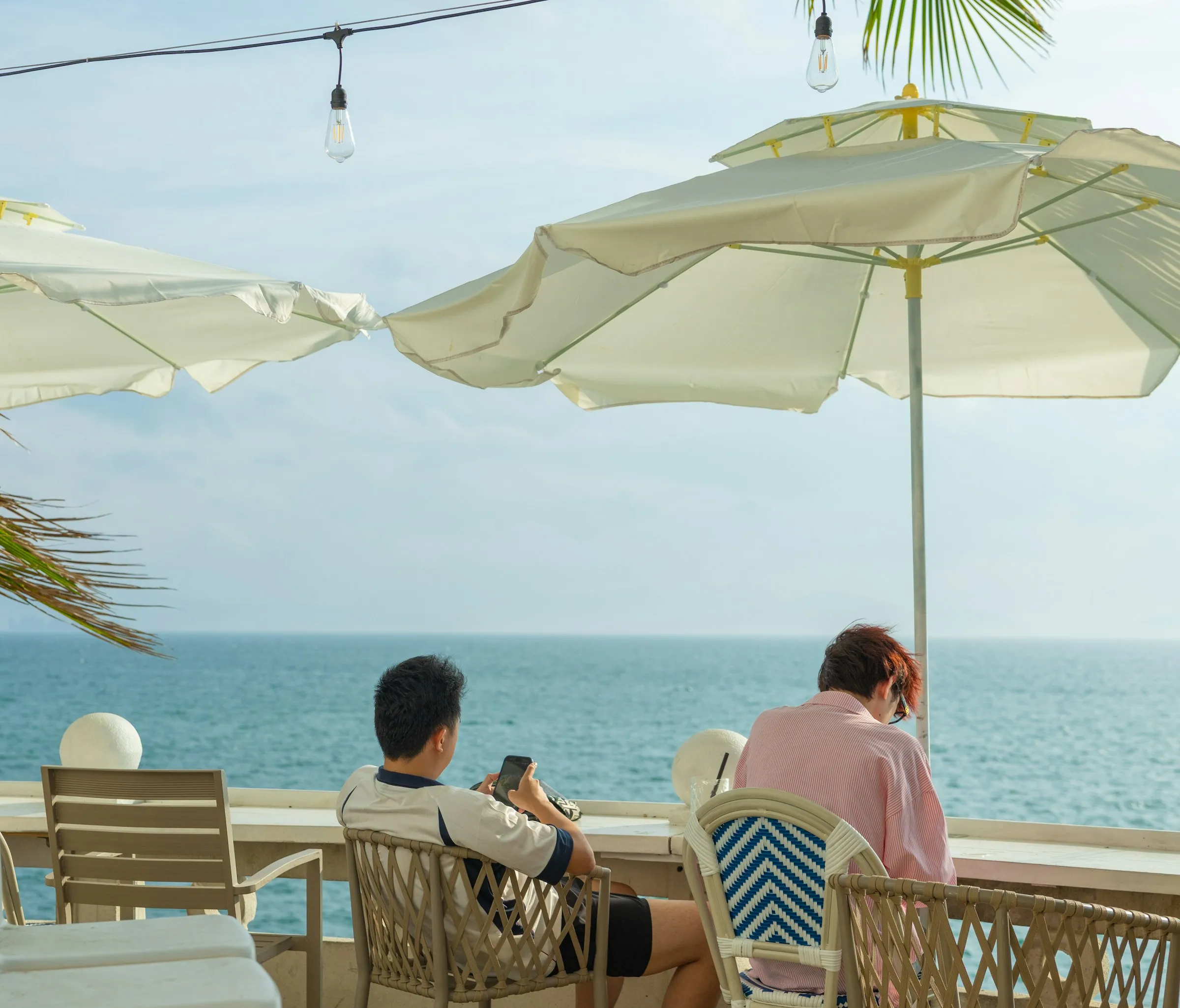 A couple relaxing at a sunny seaside café overlooking the ocean