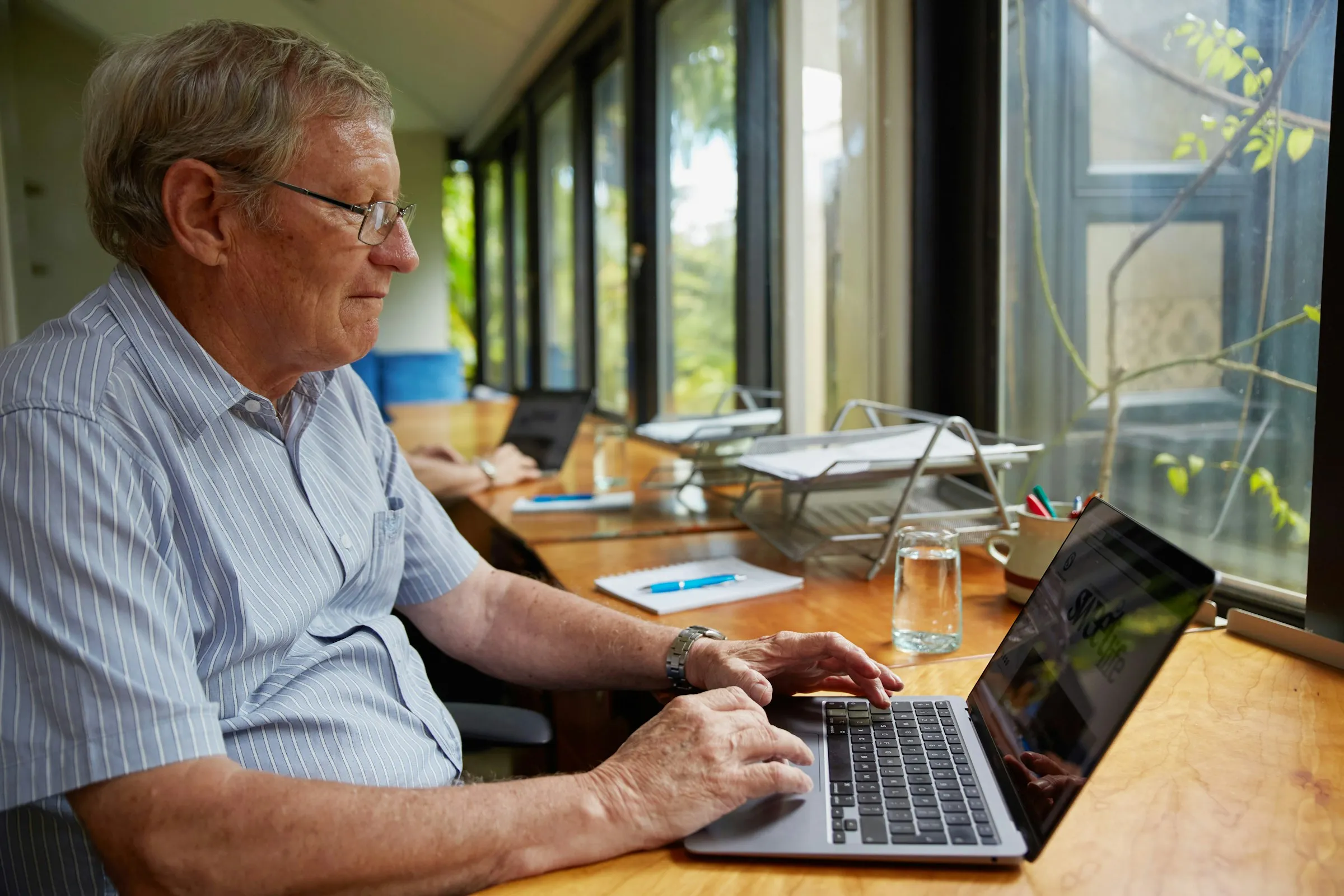 A retired investor reviewing a loan pack on his laptop at home